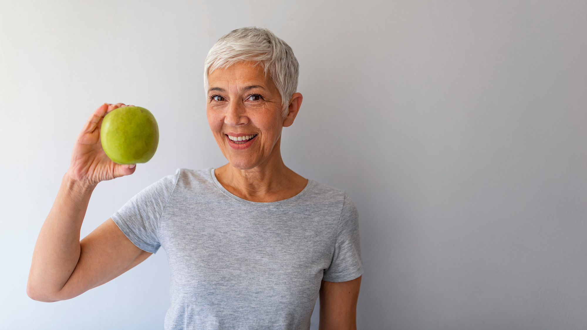 Dysphagienetzwerk Deutschland Hintergrund Frau mit Apfel in der Hand gegen Schluckbeschwerden